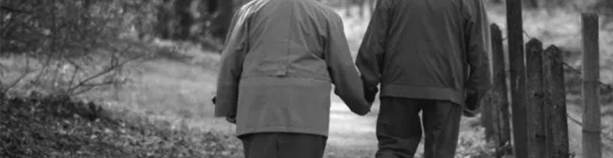 Foto una pareja mayor caminantdo de espalda y cogidos de la mano